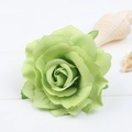 Detail of light green silk rose hair clip on white wooden surface with seashells - Green