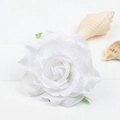 White artificial rose hair clip with green leaves on a white wooden background - White