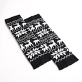 Detailed view of knitted leg warmers with reindeer and snowflake patterns in black and white - Black/White