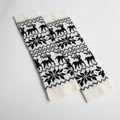 Close-up of knitted leg warmers featuring reindeer and snowflake Christmas patterns - White/Black