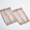 Close-up of beige knit leg warmers featuring Nordic geometric patterns and ribbed cuffs - Beige/White