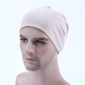 Detailed side view of a beige stretch knit dome cap on a model for a snug fit - Beige