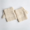 Detail of cream cable-knit leg warmers with hollow patterns and side tassels - Ivory