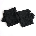Close-up of black knitted leg warmers with textured acrylic yarn and fringe details - Black