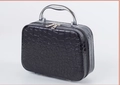 Elegant black crocodile texture makeup bag with a sturdy metallic top handle for women - Black