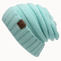 Muntgroene gebreide muts met C.C lederen label op een witte achtergrond voor de winter - Eén maat / Meerblauw