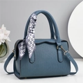 Detail einer dunkelblauen Handtasche mit vertikaler Prägung und Herzmuster-Schal - Blau