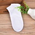 Classic white cotton low-cut boat socks with ribbed cuffs on a natural wooden background - One Size / White
