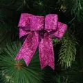 Fiocco natalizio viola glitterato appeso a un ramo di pino verde per decorazioni - Rosa Rosso