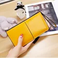 Close-up of a yellow patent leather long wallet for women with zipper and wristlet strap - Yellow