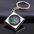 Porte-clés boussole carré argenté avec marquages verts sur un fond en cuir noir élégant - Boussole Carrée