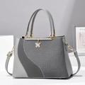 Elegante bolso patchwork gris con barra de metal dorado y colgante de mariposa chic - Gris