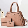Dreiteiliges rosa Handtaschen-Set mit Krokodilmuster und goldenen Details auf weißem Stein - Rosa