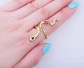 Nahaufnahme eines goldenen Schlangenrings in Wickeloptik am Finger mit Glanzeffekt - Gold