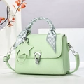 Détail d'un sac à main vert clair en cuir grainé avec foulard et pendentif étoile - Vert