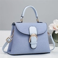 Detail of light blue crossbody bag with denim texture and gold horseshoe buckle - Blue
