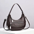 Détail du sac croissant marron foncé montrant la texture cuir huilé et la poche zippée - café