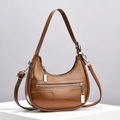 Detail view of brown crescent shoulder bag with glossy finish and silver metal zipper accents - Earthy Yellow