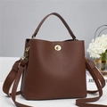 Brown lychee leather bucket bag with gold clasp and wide strap on white base - Coffee