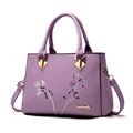 Lavender faux leather handbag with floral embroidery and gold hardware details - Purple