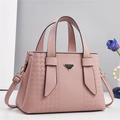 Détail du sac à main en cuir rose avec logo triangulaire et finitions dorées - Rose