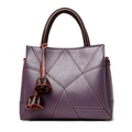 Bolso tote de cuero morado con patrón de lichi, asas marrones y colgante de borla - Morado