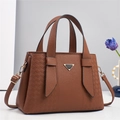 Elegante bruine leren handtas met gouden hardware en driehoekig metalen detail - Aardgeel