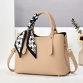 Detail of light tan tote bag with lychee texture and silk scarf wrapped handle - Apricot