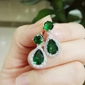 Detailed close-up of teardrop emerald green zircon earrings with silver setting - Earring Posts / Green