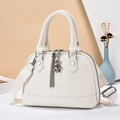 White shell-shaped crossbody bag in lychee leather with patterned strap and bear charm - White