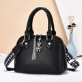 Women black lychee textured handbag with shell shape and wide woven shoulder strap - Black