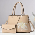 Close-up of elegant lily flower embroidery on beige leather tote bag with silver hardware - Khaki