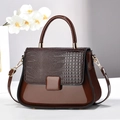 Detail of dark brown faux crocodile leather texture and glossy finish on handbag - Coffee