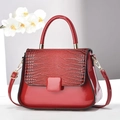 Detail of red patent leather handbag with crocodile pattern and golden hardware - Wine Red