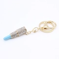 Detailed macro view of gold lipstick keychain with blue top and clear rhinestone inlay - Large / Blue
