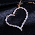 Détail du pendentif cœur évidé doré avec cristaux blancs sur fond en cuir noir - Doré