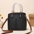 Minimalist black litchi grain bucket bag with brown handles and gold hardware accents - Black