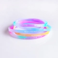 Macro detail of colorful gradient silicone wristbands with printed motivational letters - Multicolor