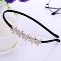 Black thin metal headband featuring five golden rhinestone flowers on a white surface - Gold Five Flowers