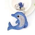 Detail of blue rhinestone dolphin keychain with leather tassel and silver bell accessory - Blue