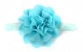 Close-up of a large light blue chiffon flower headpiece on a matching elastic headband - Blue