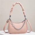Detailed view of pink moon bag featuring embossed leather texture and silver chain accents - Pink