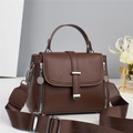 Detail of a brown lychee pattern leather crossbody bag with silver hardware and wide strap - Coffee