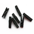 Set of seven black wooden photo clips with metal springs on a plain white background - Black