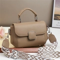Detailed macro view of litchi-grain leather texture with decorative silver metal buckle - Khaki