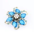 Dettaglio macro di spilla a fiore con gemme blu e strass su base di bronzo - Blu