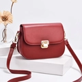 Elegante borsa a tracolla rosso vino con fibbia dorata su espositore bianco minimalista - Rosso
