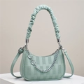 Detail der mintgrünen Halbmond-Tasche mit Lychee-Ledertextur und silberner Kette - Grün