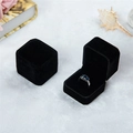 Detailansicht einer offenen schwarzen Samtschmuckbox mit einem silbernen Ring mit blauem Stein - Schwarz