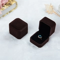 Braune Samt-Ringbox in quadratischer Form mit blauem Edelsteinring im Detail gezeigt - Kaffeebraun